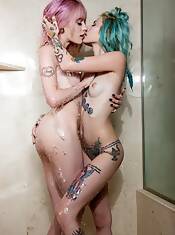 two petite tattooed girls showering together